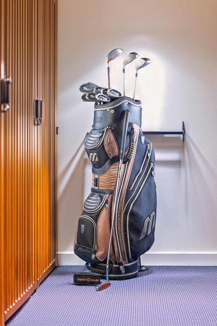 journey-01 Golf equipment bag placed in a locker room setting, ideal for sports and leisure imagery.